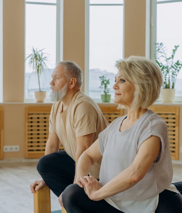 A person practicing a gentle stretching exercise in a calm room.