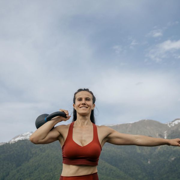 Smiling woman in sportswear feeling energetic and happy outdoors.